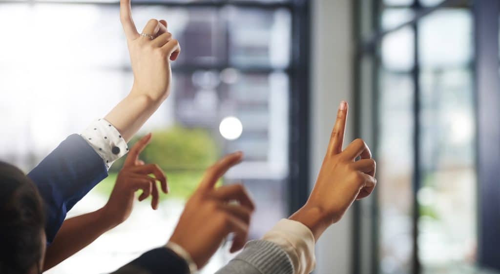 closeup of people raising their hands