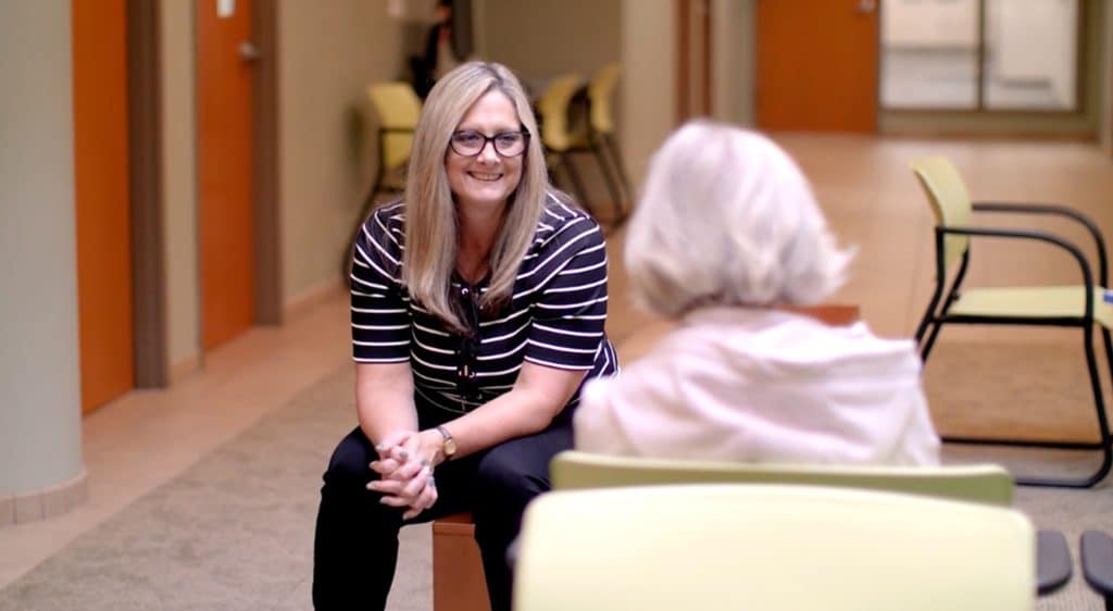 Woman speaking with older woman in a waiting room