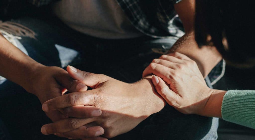 people holding hands and arms for comfort